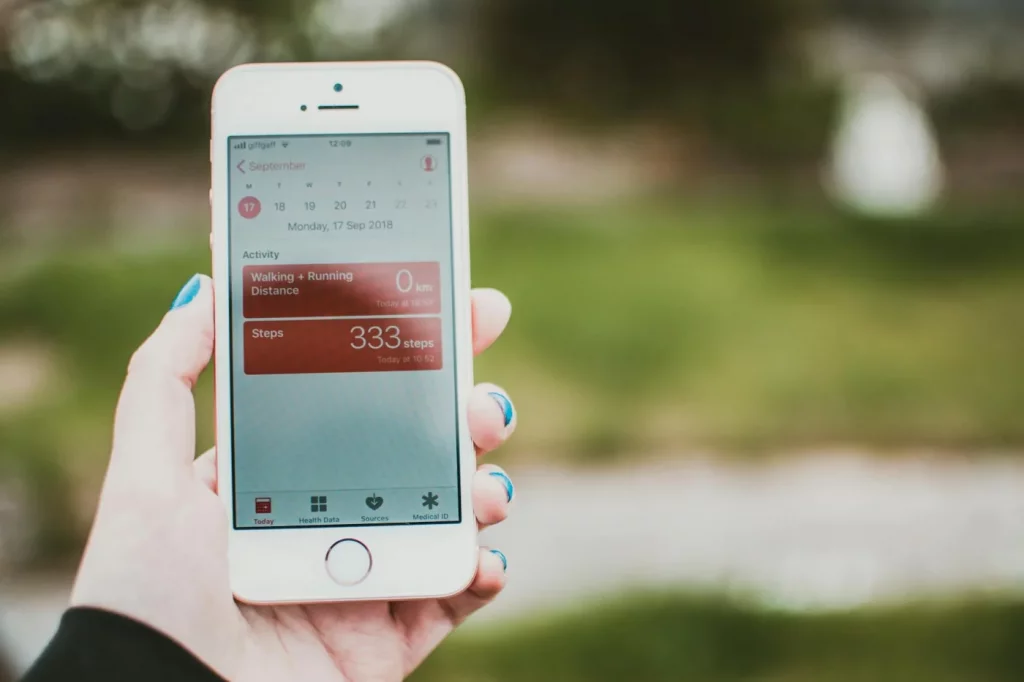 Smartphone fitness dashboard outdoors, illustrating the best habit tracker app free for step and distance goals