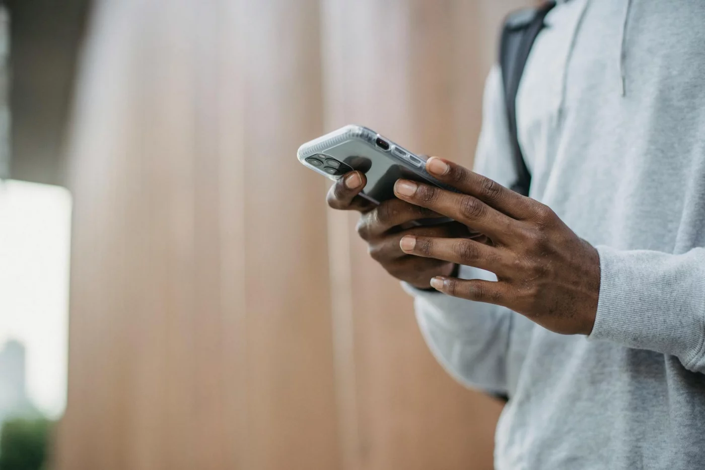 Young man using a phone to compare the best habit tracker app free options for no-journal tracking