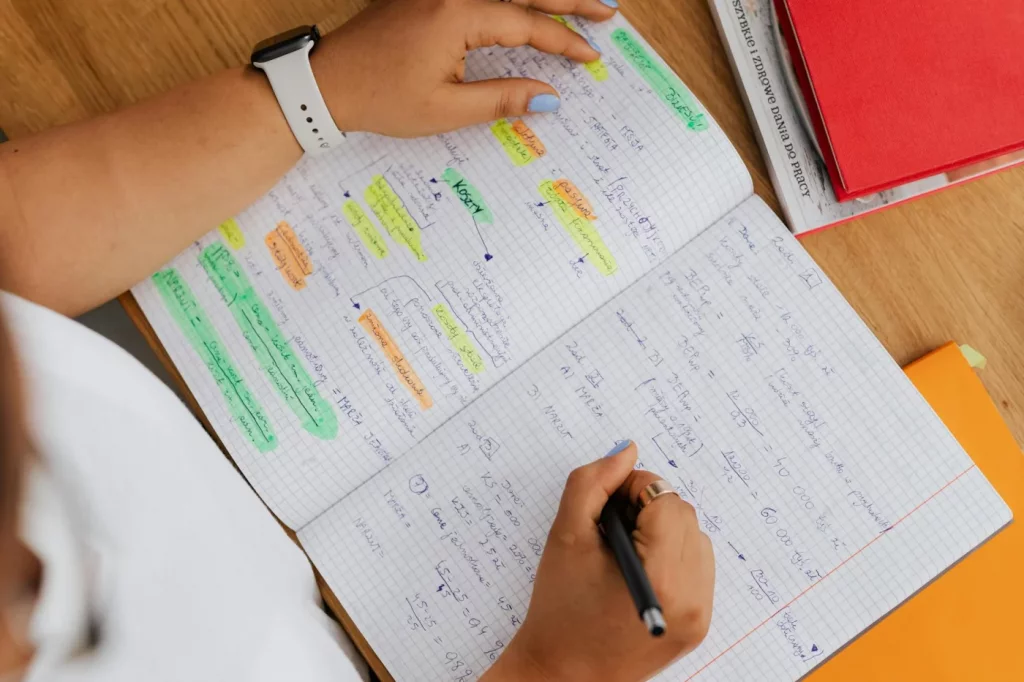 Notebook notes and colorful markers illustrating the best study methods for each subject