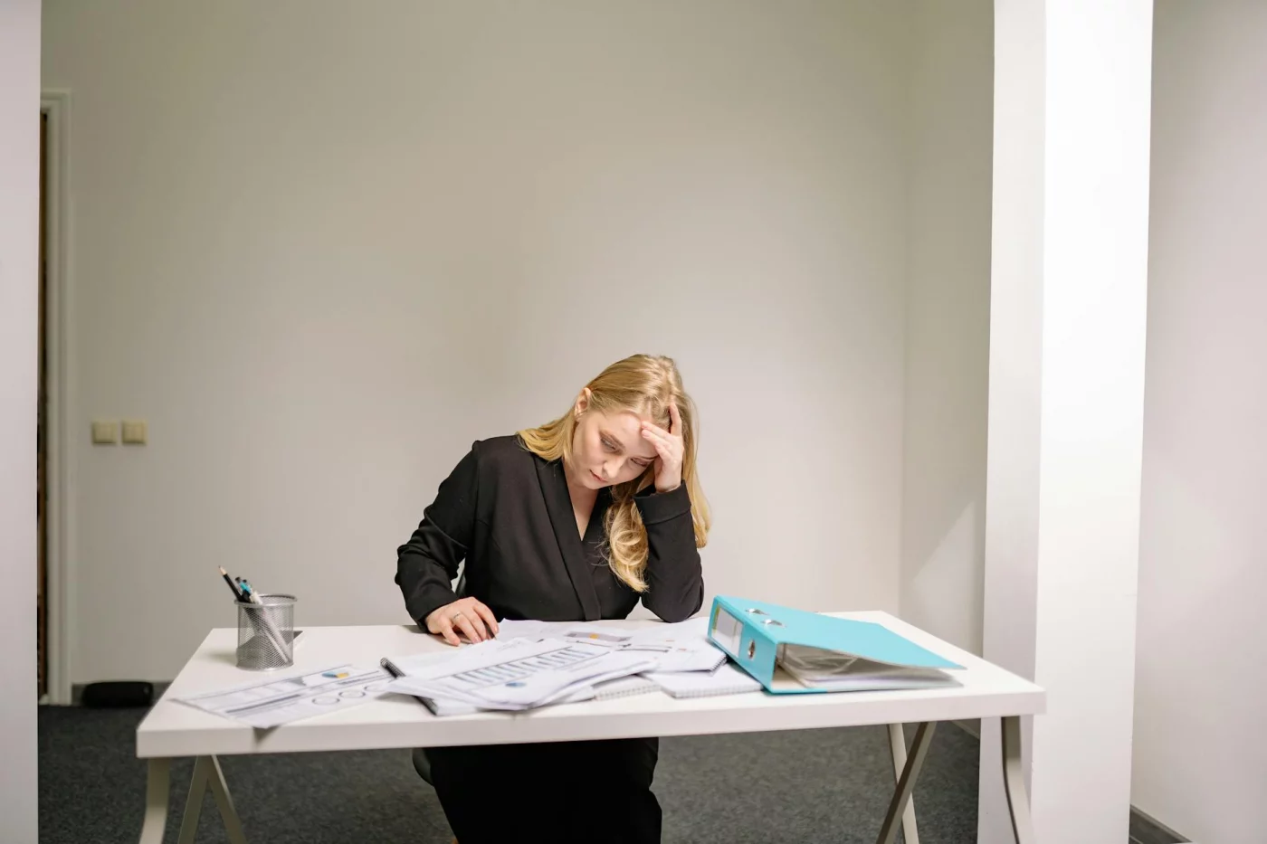 Stressed businesswoman overwhelmed by paperwork, illustrating cognitive distortions examples linked to anxiety