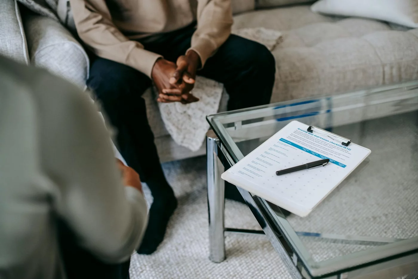 Patient with clasped hands speaking to a psychologist during a flow neuroscience clinical trials FAQ discussion