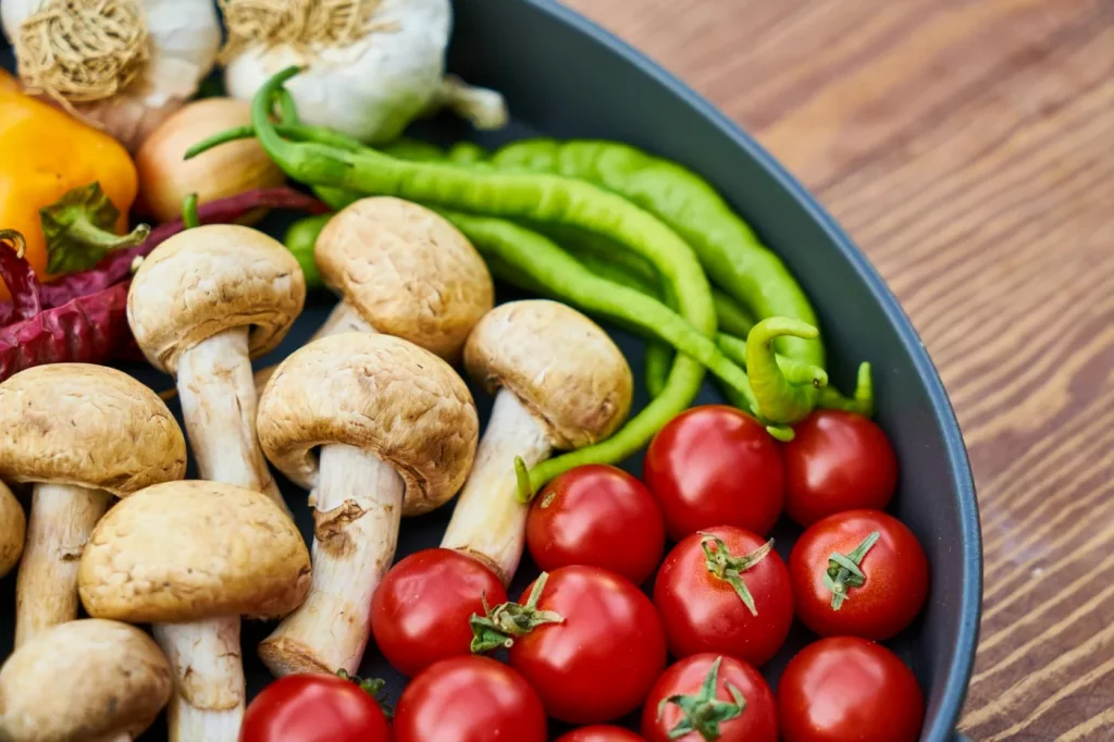 Fresh vegetables and mushrooms in a pan, illustrating natural sources of glutamate in food