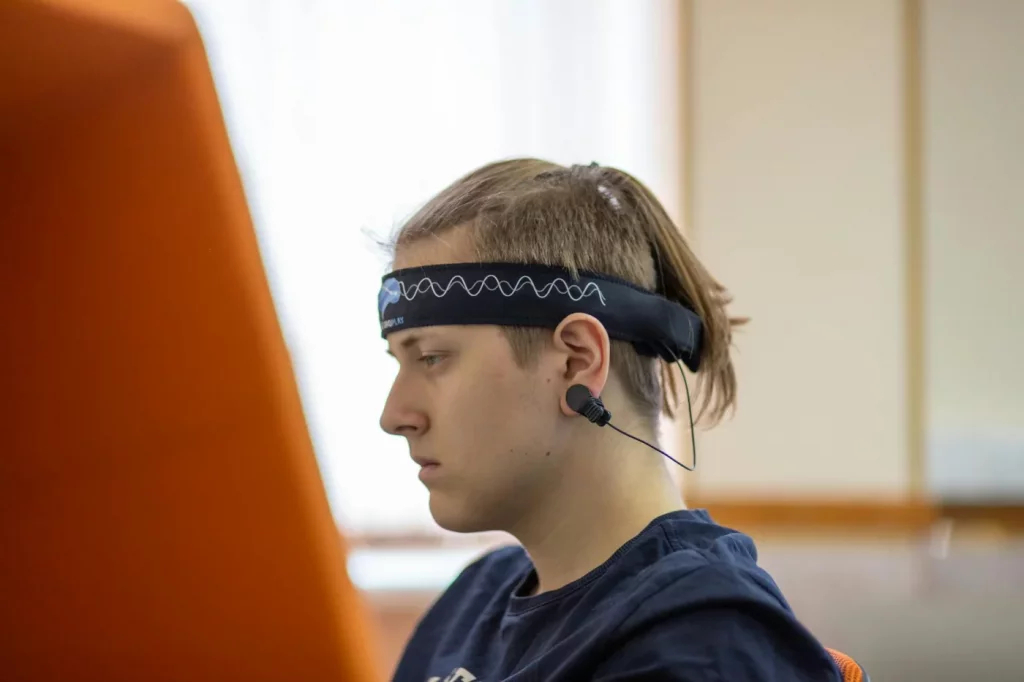 Student wearing an EEG headband while studying, showing how brain computer interfaces improve attention