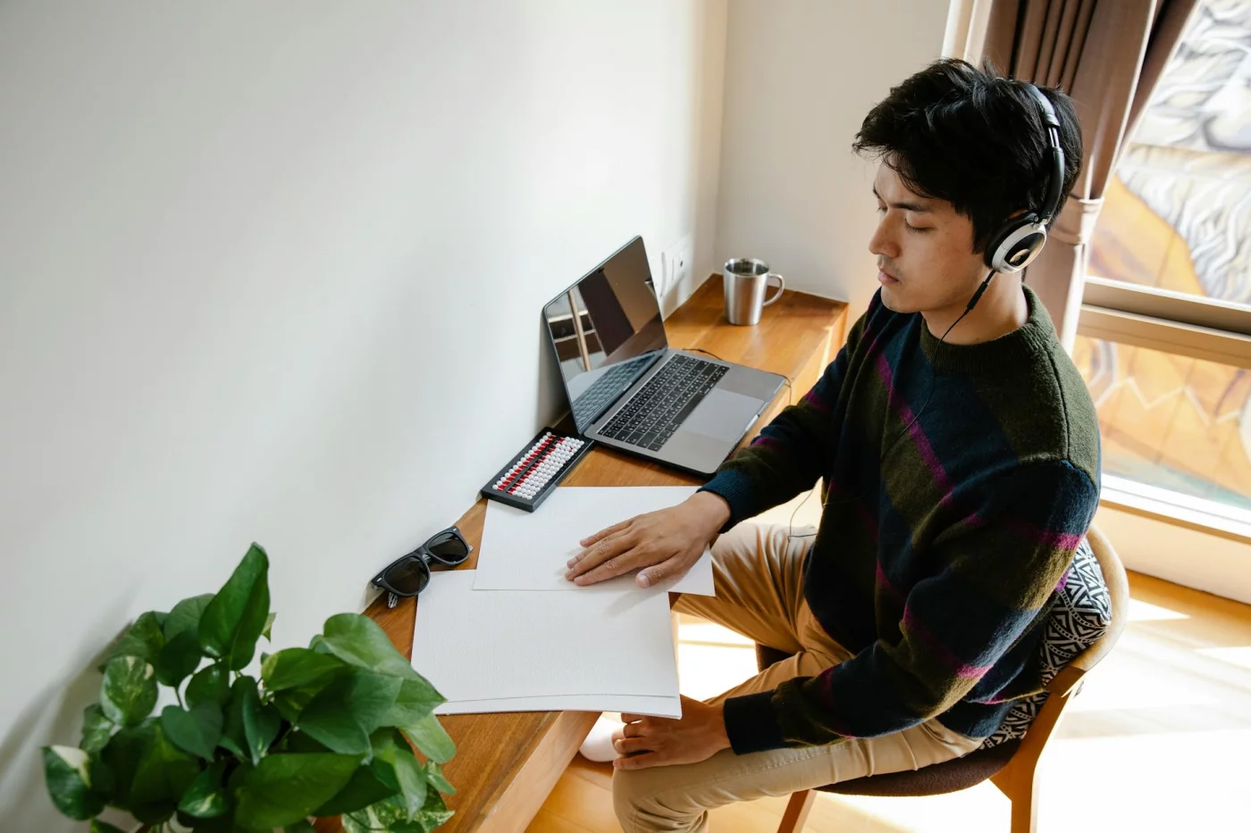 Man wearing headphones at a desk shows how to improve focus while studying under stress with a calm workspace