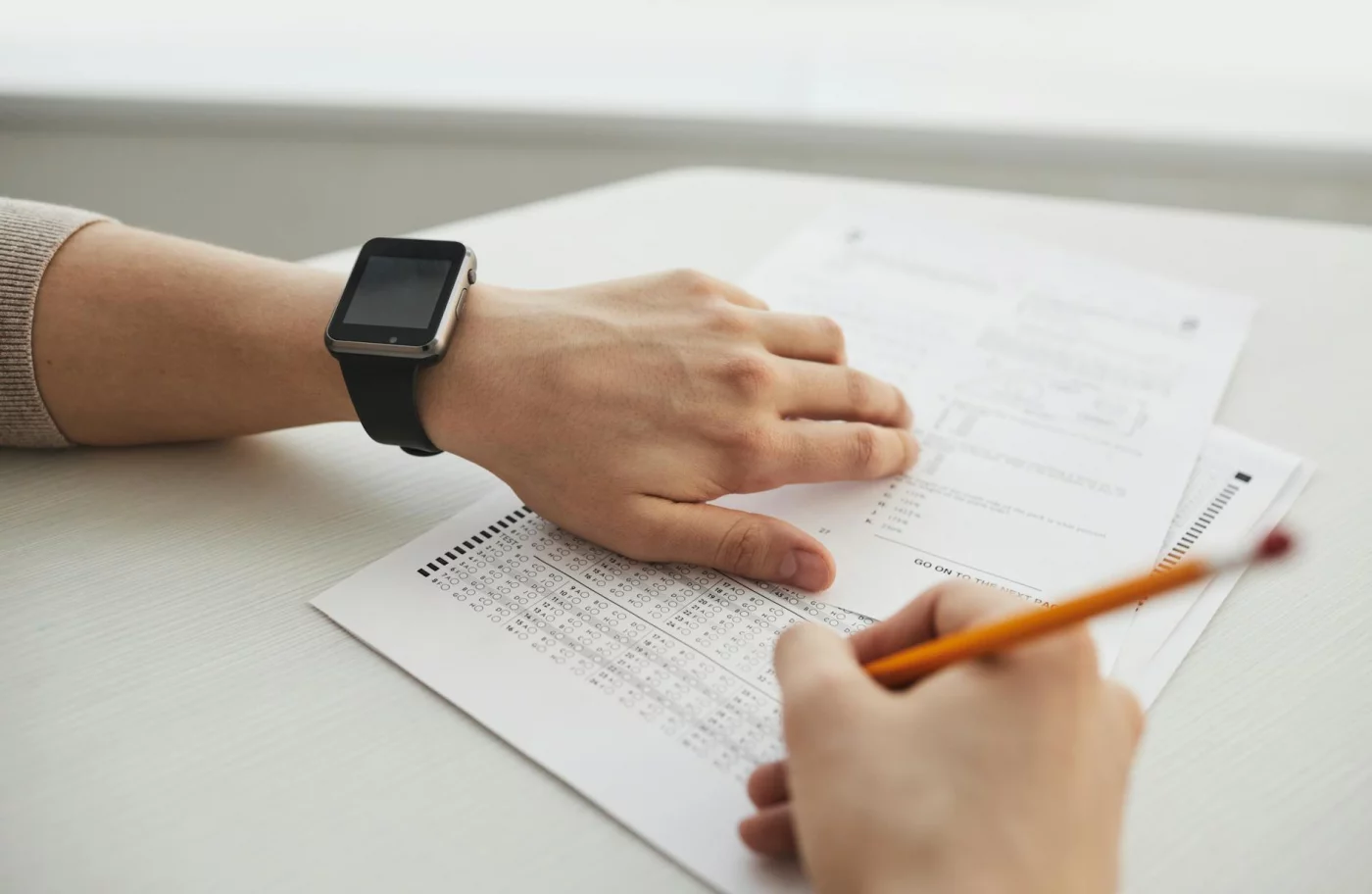 Student completing a multiple-choice exam with a pencil after thinking, i did bad on a test i studied hard for