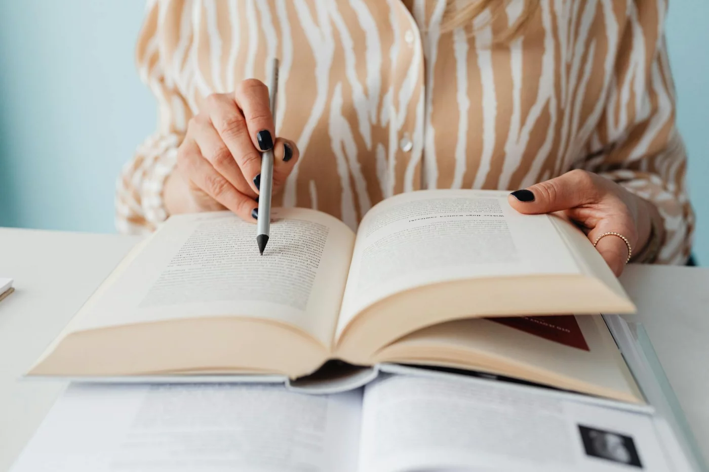 Student pointing at textbook text while reviewing what are tags in notes for an exam guide