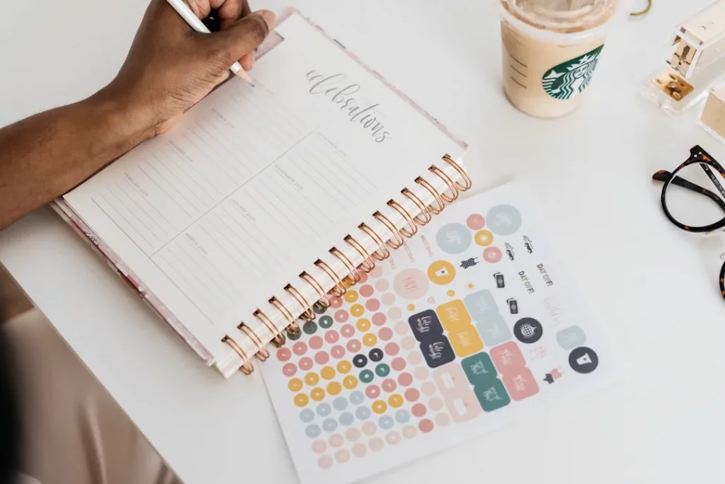 Person writing at a table while planning tasks, illustrating what is time and energy management