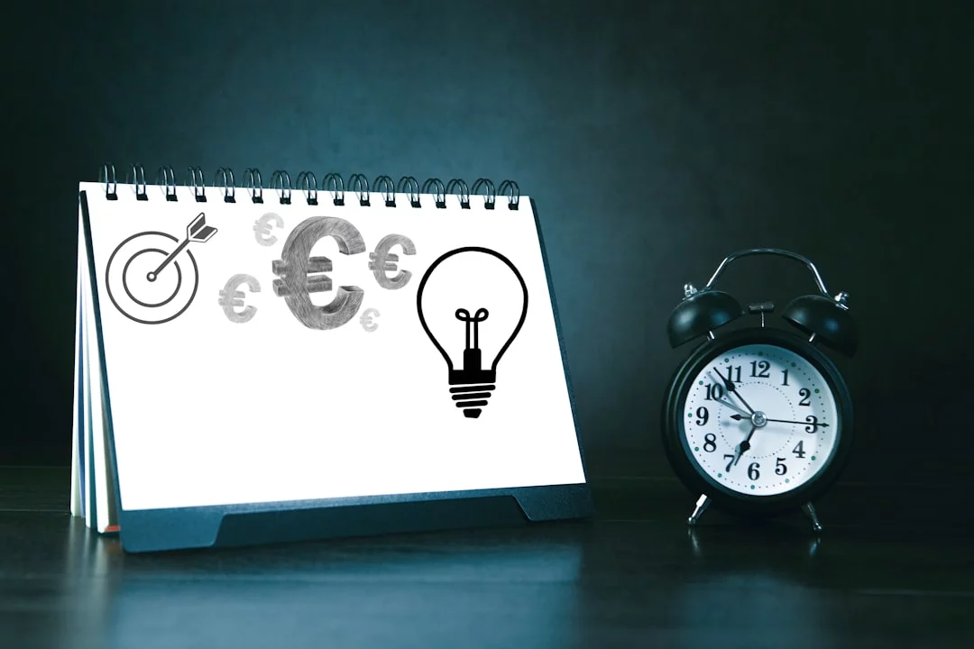 Desk calendar with business symbols and alarm clock illustrating what is time and energy management FAQs