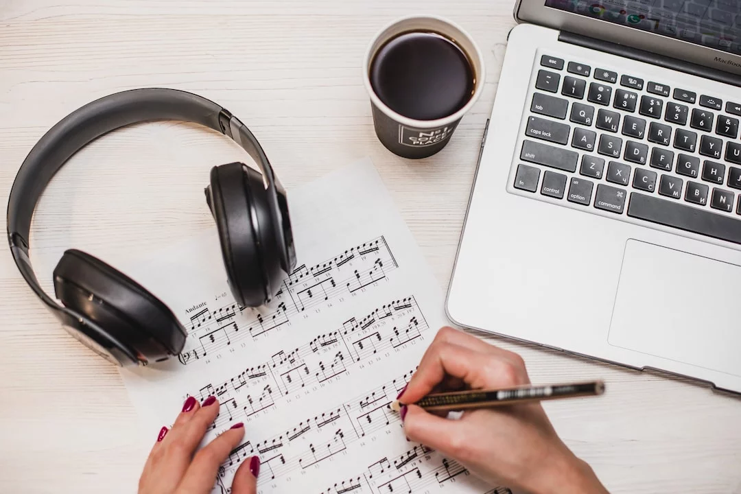 Person writing notes while considering what music should you listen to while studying for better focus