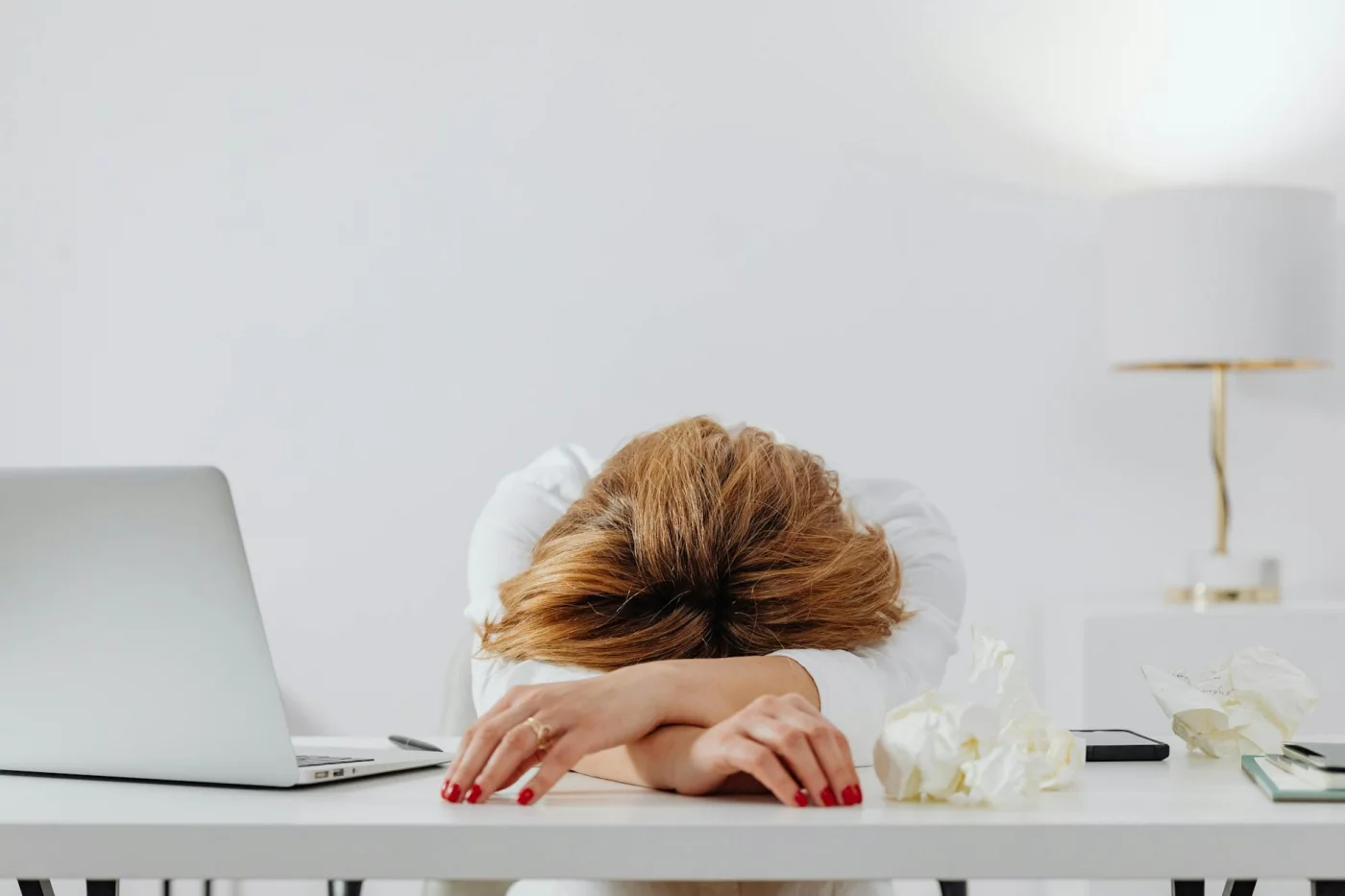 Tired woman at her desk illustrates what to do when emotionally exhausted at work and why rest matters