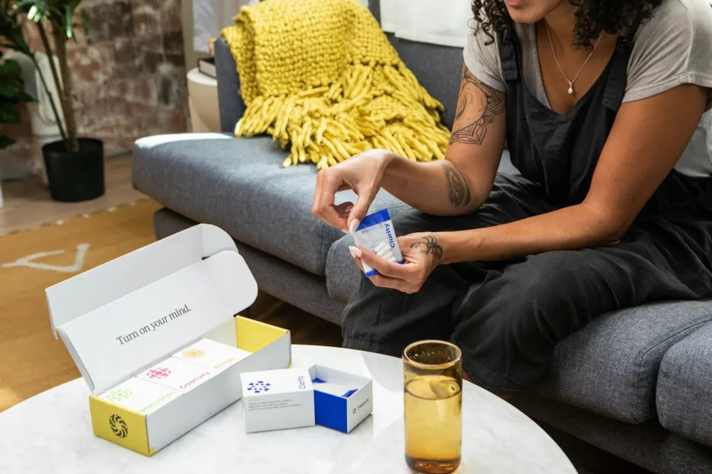 Woman on a sofa comparing supplements while exploring which nootropics actually work for healthy people