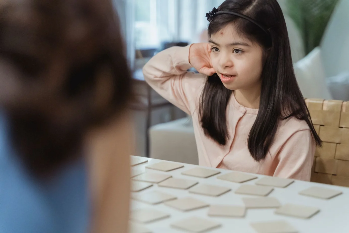 How to Improve Memory, Focus, and Learning With Science-Backed Habits Young girl playing a memory game indoors, illustrating how the best foods for memory and focus support learning