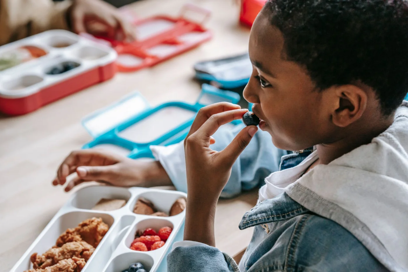 How to Improve Memory, Focus, and Learning With Science-Backed Habits Child enjoying a healthy snack at lunch, featuring some of the best foods for memory and focus