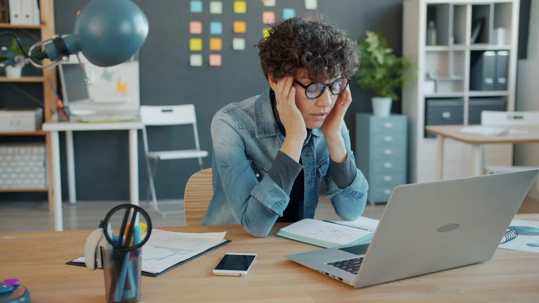 Early Signs of Burnout at Work You Might Be Ignoring Stressed employee at a laptop showing early signs of burnout at work in a quiet office