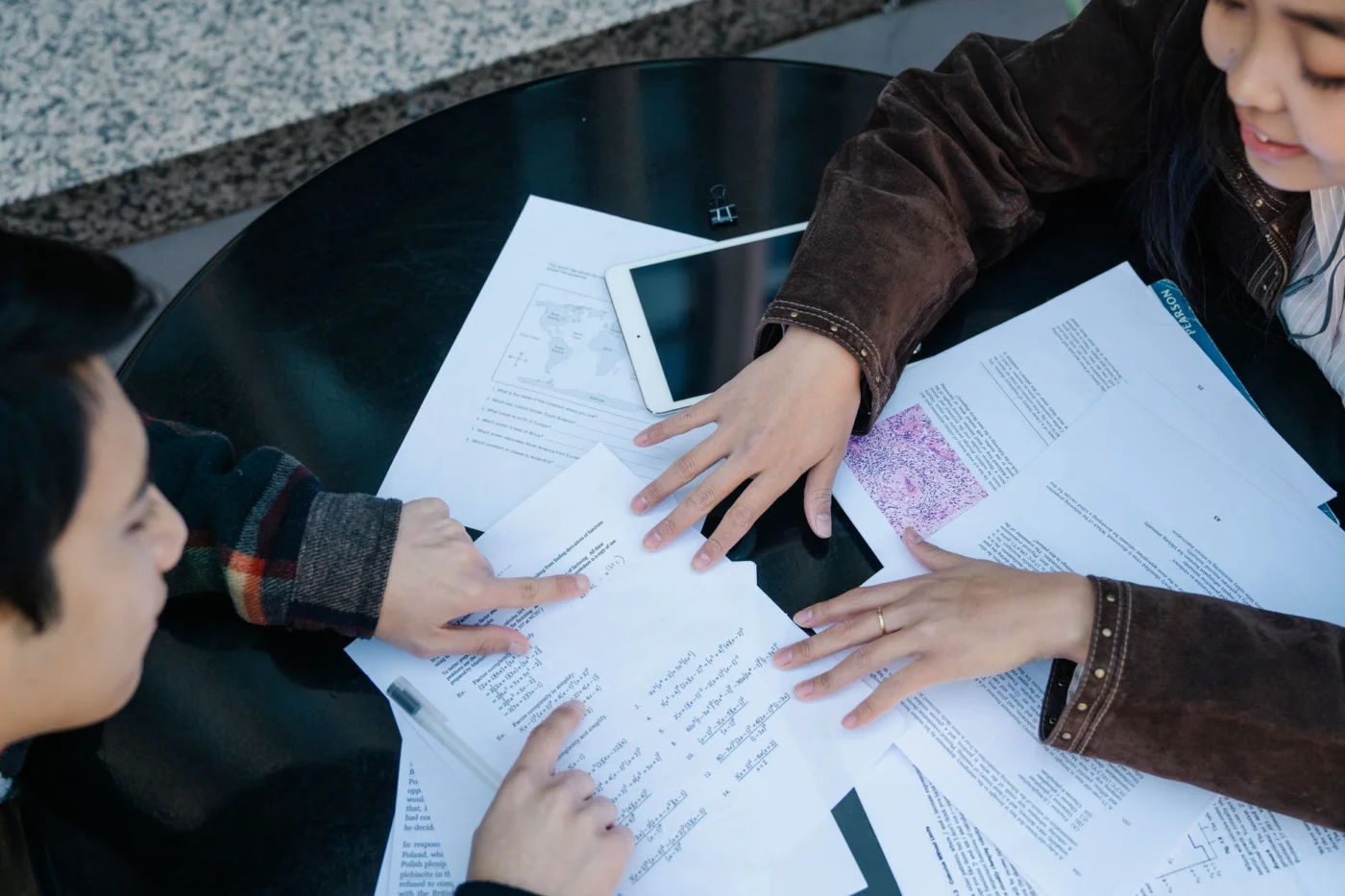 How AI Affects Student Learning Without Hurting Memory or Thinking Students studying together with papers, discussing how does ai affect education negatively and positively
